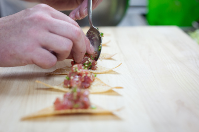 Chef preparing nachos with fish extreme closeup